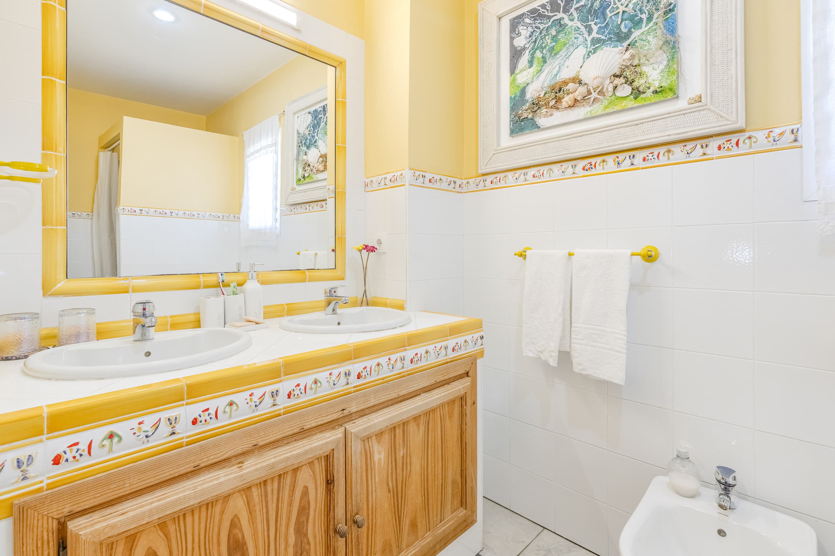 Baño en suite con lavabo doble y azulejos sevillanos