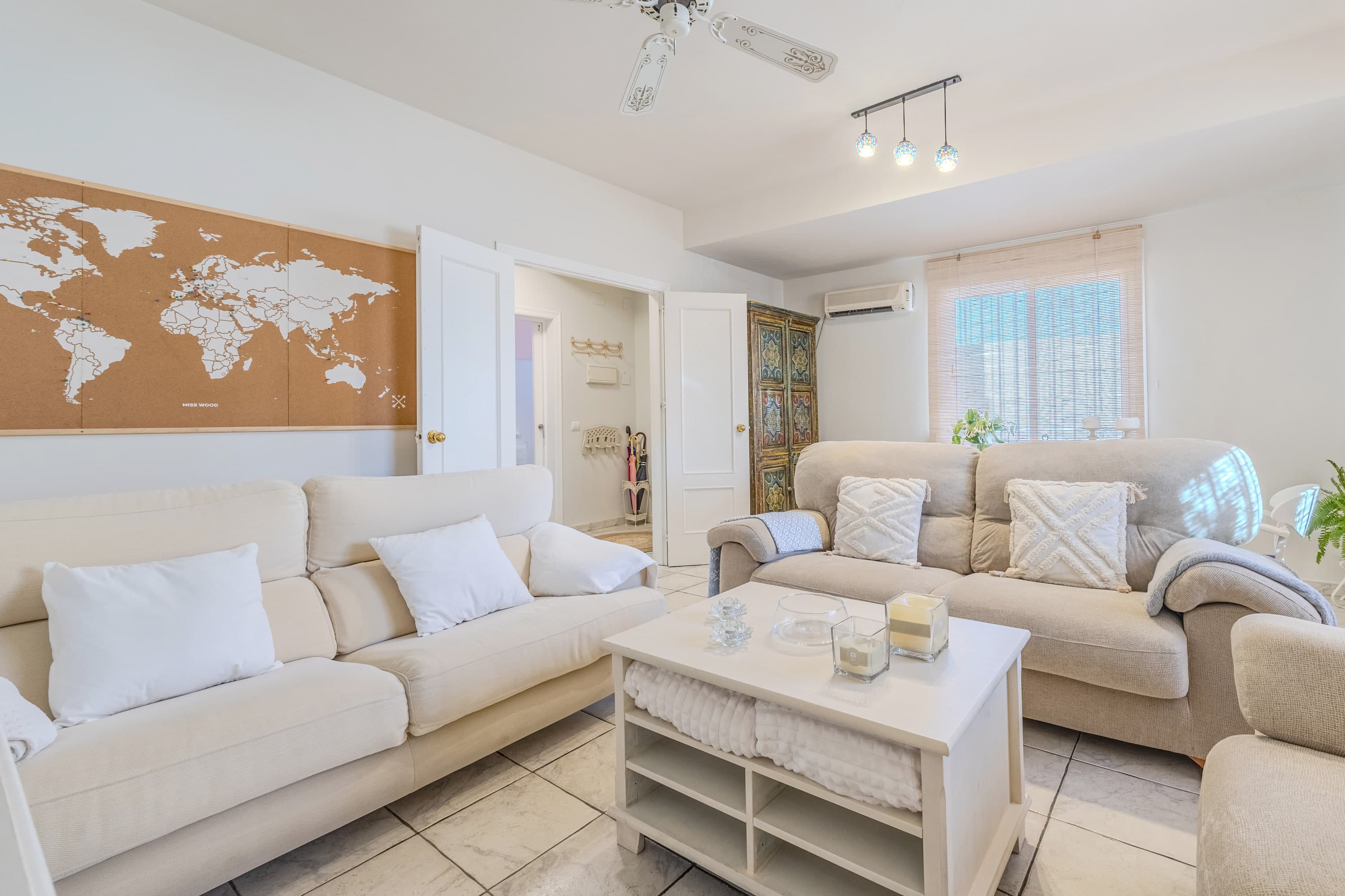 Salón principal diáfano con sofás confortables, lámparas de lectura y techos altos